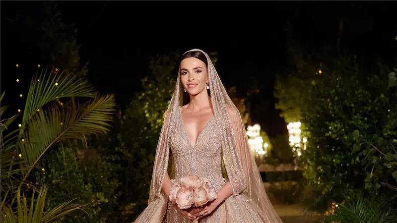 باللون الذهبي.. الإطلالة الثانية لزين قطامي في حفل زفافها على سيليو صعب