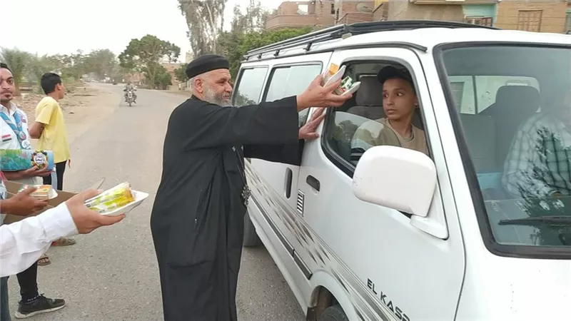 رمضان يجمعنا.. راعي كنيسة بسوهاج يوزع وجبات وعصائر على الصائمين وقت الإفطار 