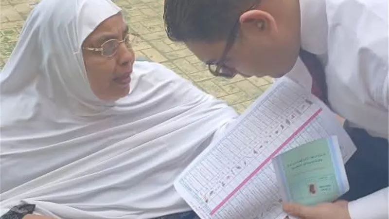قاضٍ يساعد مسنة على الإدلاء بصوتها داخل لجنة بإيتاى البارود 