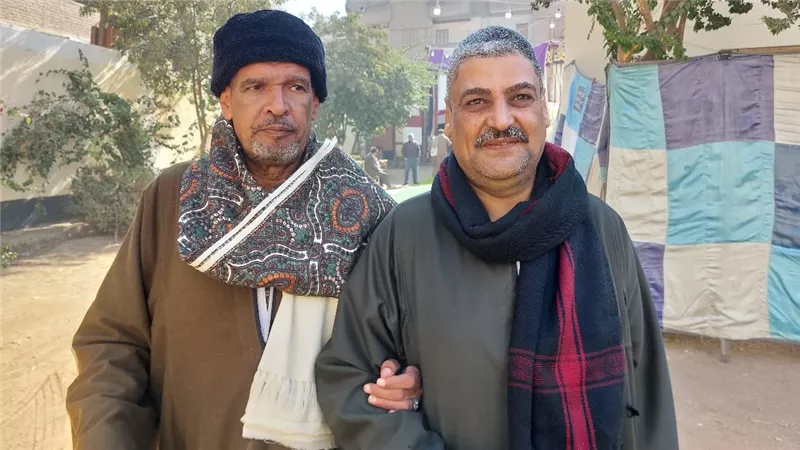 مدير مدرسة يصل لجنة الاقتراع متكئًا على زميله للإدلاء بصوته في انتخابات النواب