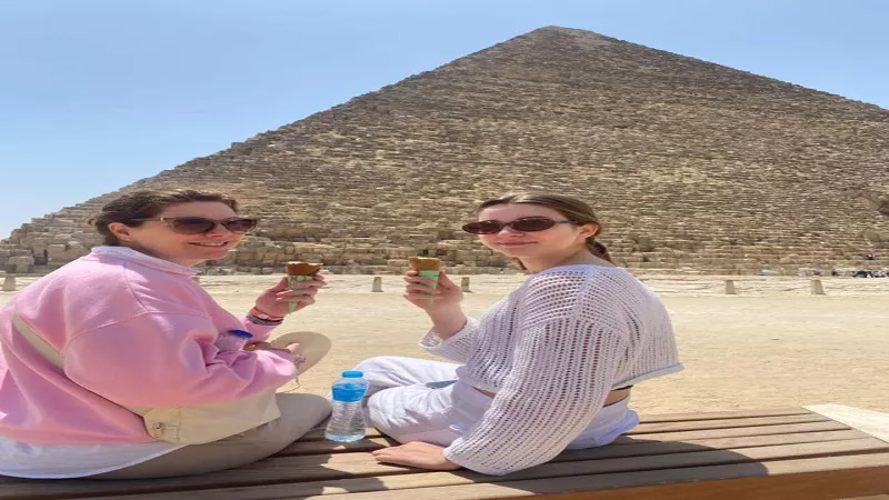بالآيس كريم.. سائحات تستمتع بالإجازة من أهرامات الجيزة